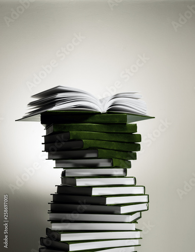 An open book on a stack of red books in the form of a spiral.
