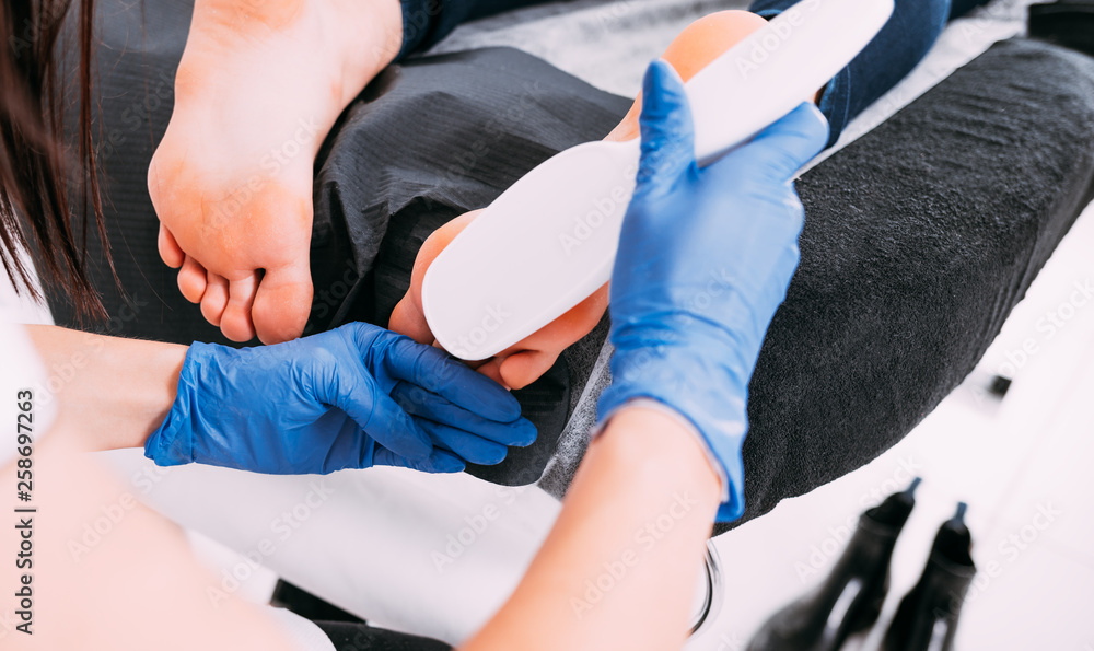 Obraz premium Peeling feet pedicure procedure at cosmetic salon