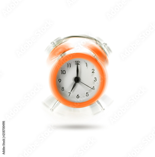 Orange ringing alarm clock isolated on white background.