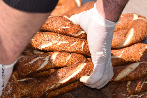 Man with food hygiene gloves handling bread / Turkish Simit 