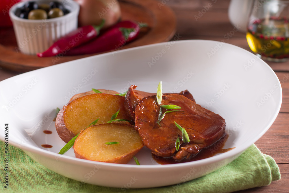 Fried potatoes and meat slices in sauce, simple country dish Fried potatoes and meat slices in sauce, simple country dish