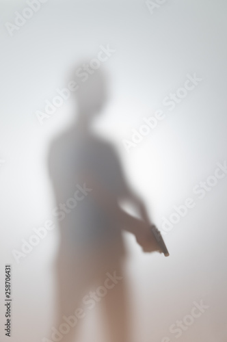 blurred silhouette of a man with a gun © luchschenF