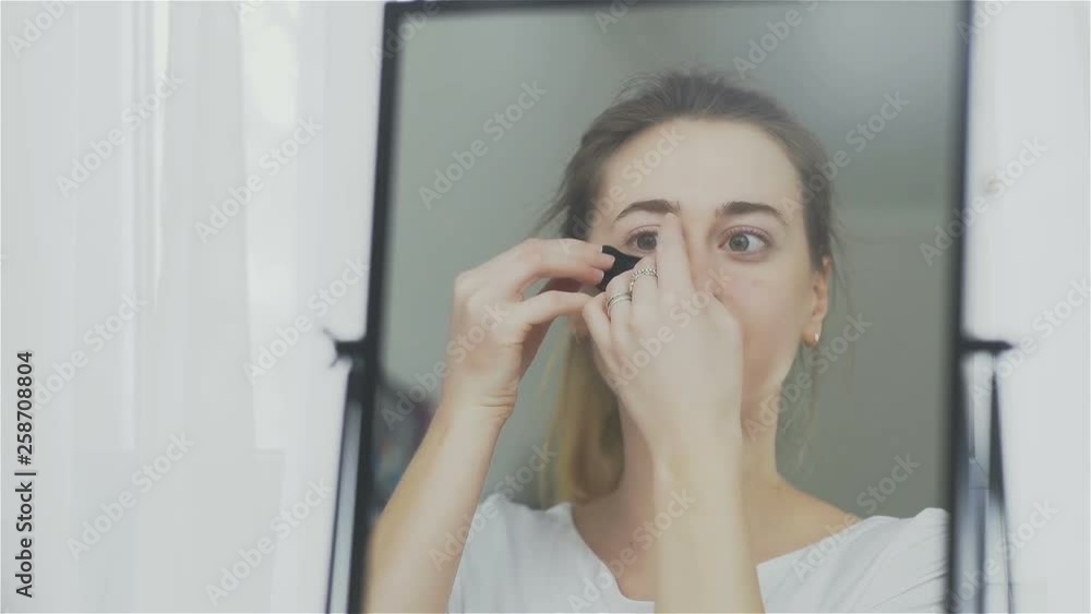 Woman imposes under eyes patches of a refreshing Collagen hydrating mask. Woman imposes under eyes patches of a refreshing Collagen hydrating mask.