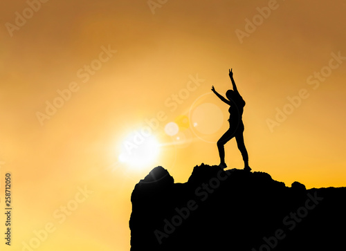 Silhouette - happy young girl on top of mountain