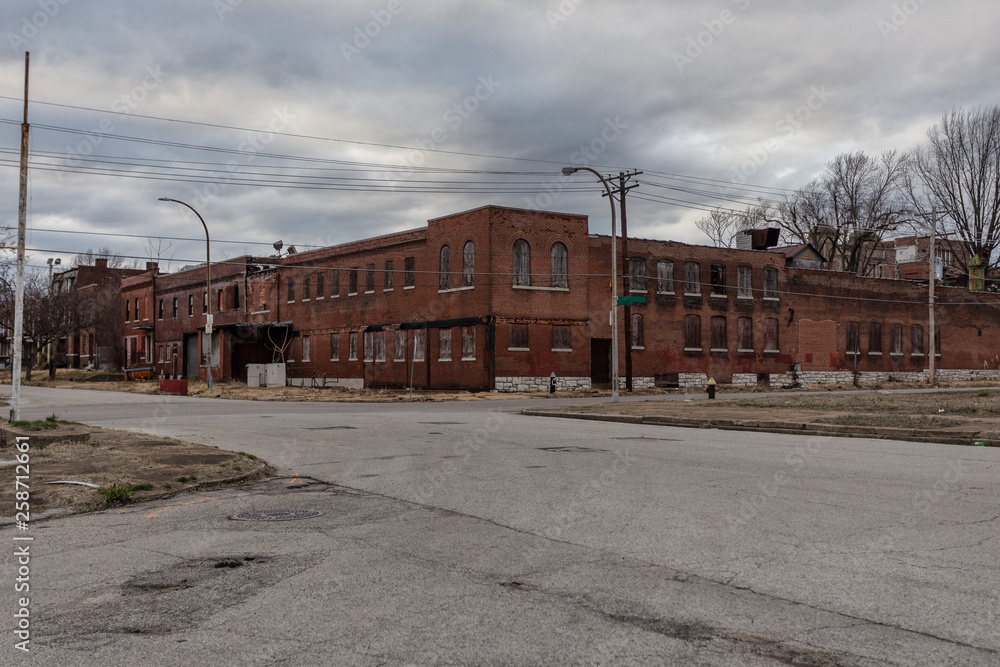 Boarded up and abandoned red brick apartment building in depressed urban area