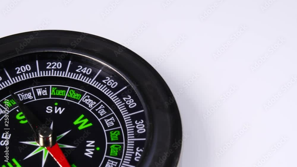 Close up compass rotating on white background. Travel, tourism and exploration Close up compass rotating on white background. Travel, tourism and exploration