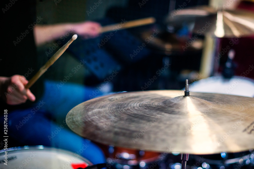 Professional drum set closeup. Man drummer with drumsticks playing drums and cymbals Professional drum set closeup. Man drummer with drumsticks playing drums and cymbals