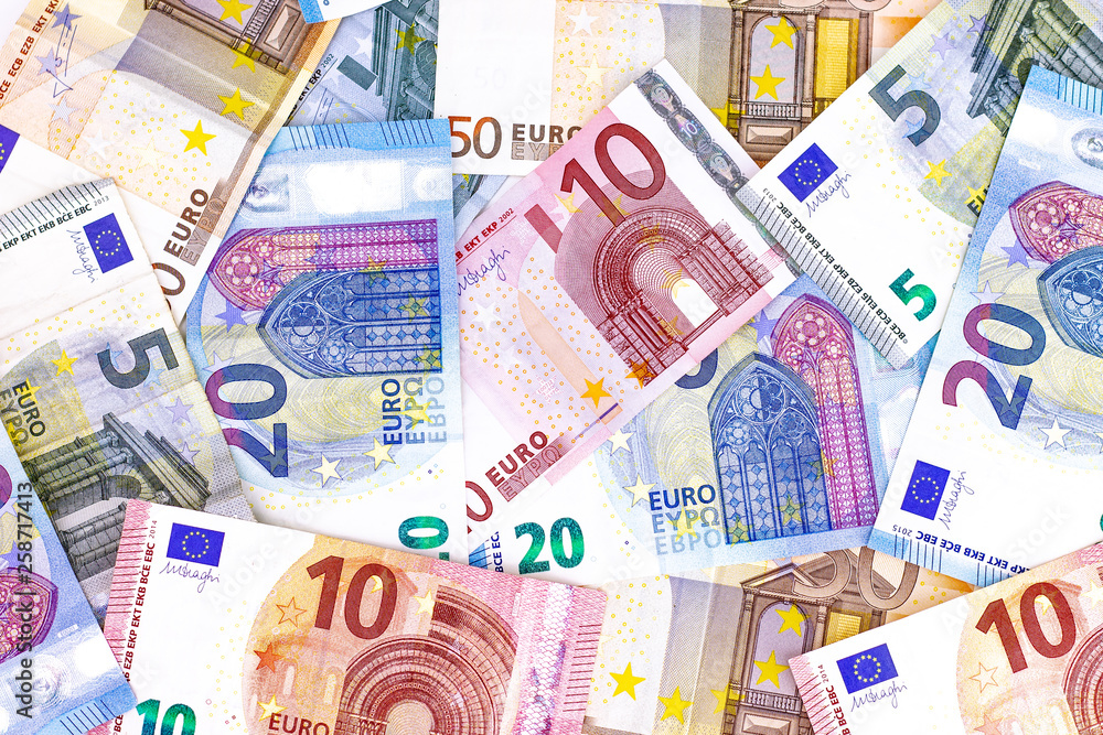 Different kind of euro money banknotes and coins on the table with white background from above view Different kind of euro money banknotes and coins on the table with white background from above view