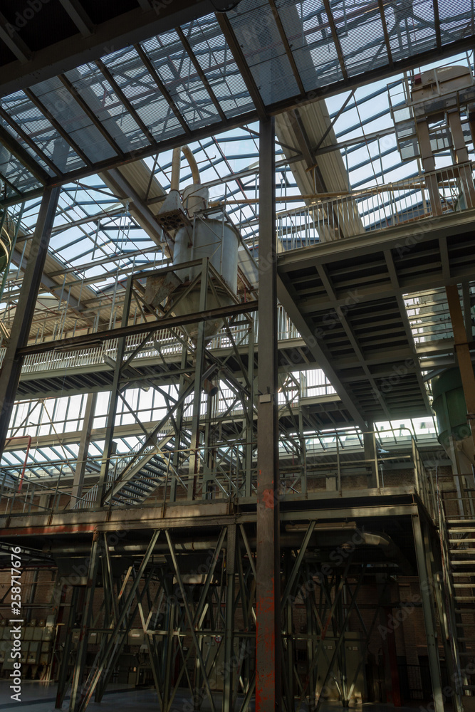 Industrial background, old abandoned factory hall with stairs and day light