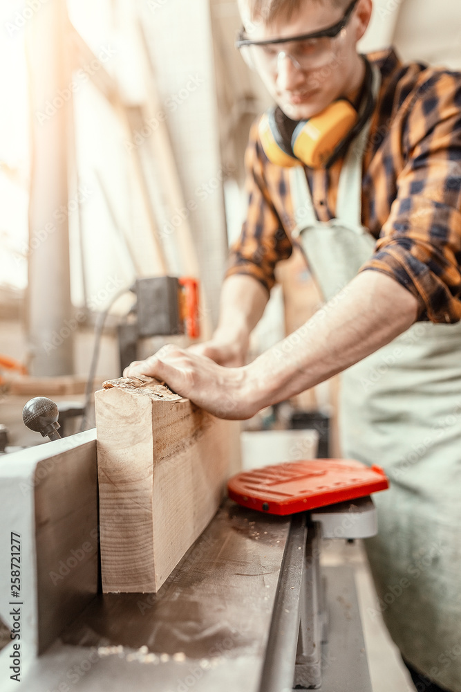 Man carpenter working with wooden workpieces at the construction site. Repair and job concept