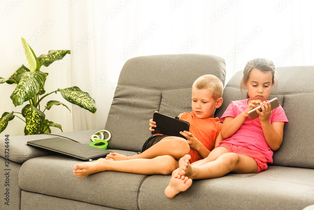brother and sister sitting on couch at home using mobile phone. Close up surprised daughter and frustrated son looking at device screen. Technology new generation addicted with gadgets concept brother and sister sitting on couch at home using mobile phone. Close up surprised daughter and frustrated son looking at device screen. Technology new generation addicted with gadgets concept