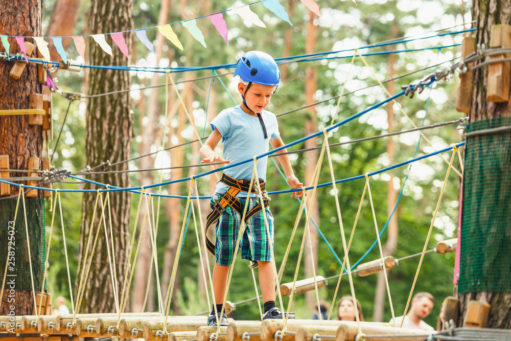 Fototapeta premium Five year boy on rope-way in forest