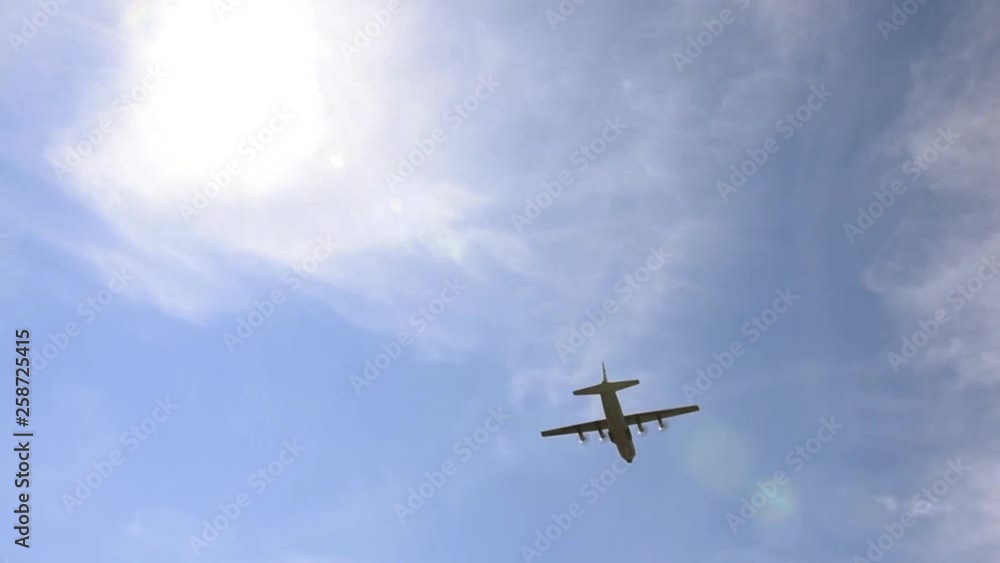 Lockheed C-130 Hercules flying above in blue sky Lockheed C-130 Hercules flying above in blue sky