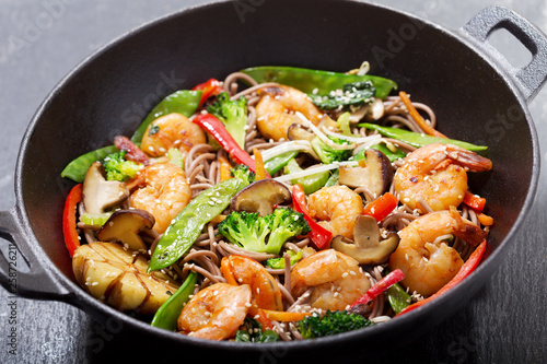 Stir fried noodles with shrimps and vegetables in a wok photo