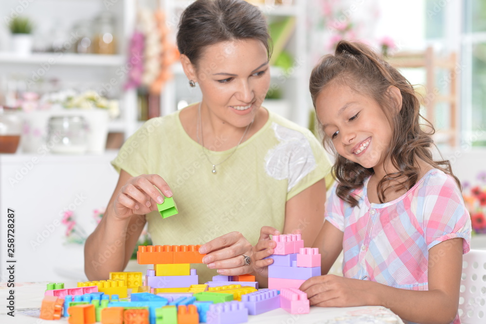 Portrait of little girl and her mother playing Portrait of little girl and her mother playing