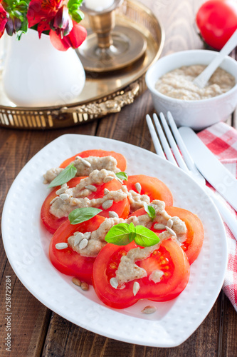 Sweet tomato salad with sunflower seed sauce, selective focus