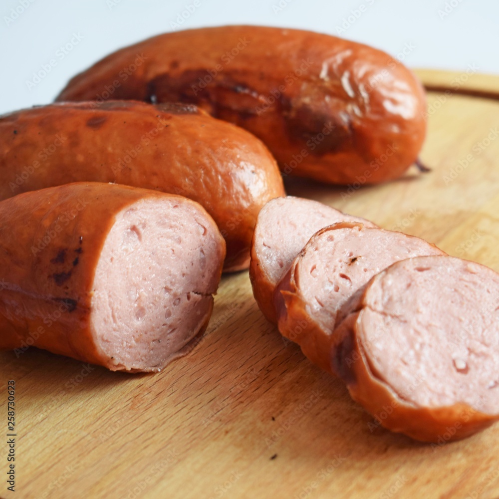 Sausages fried on a fire on a wooden background. Sausages fried on a fire on a wooden background.