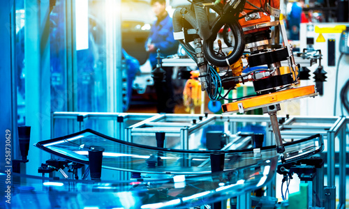 In the automotive production line, the automated robotic arm for automotive glass coating is working.