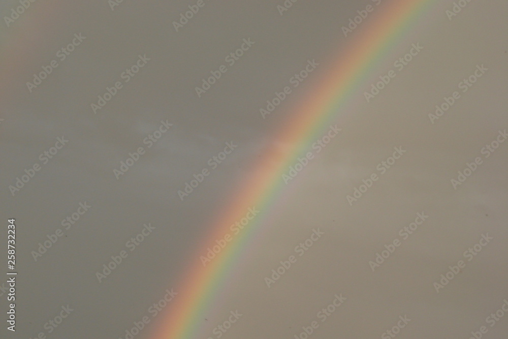 Rainbow in the cloudy sky after the summer rain captivates the look of any person. Rainbow in the cloudy sky after the summer rain captivates the look of any person.