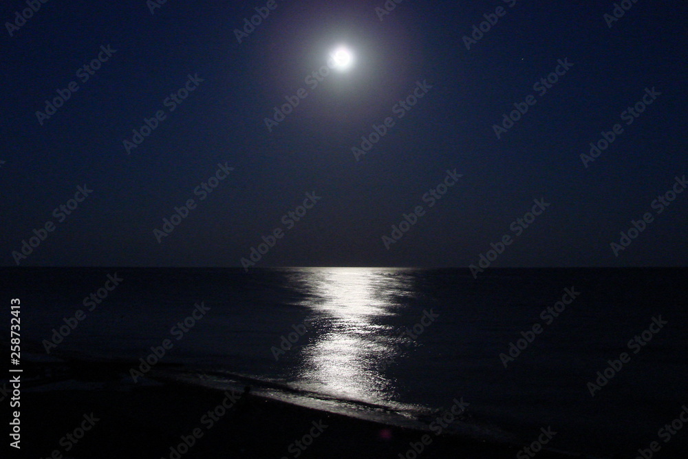 The night landscape of a calm water surface of the Black Sea with a reflection on it's lunar path. The night landscape of a calm water surface of the Black Sea with a reflection on it's lunar path.