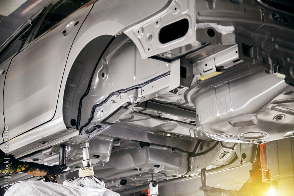 The robots in the car manufacturing plant are helping the car body to be glued at the seams. The robots in the car manufacturing plant are helping the car body to be glued at the seams.