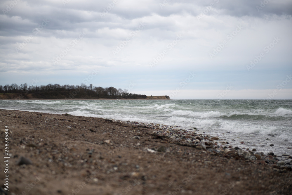 View of the baltic sea and stone beach, stormy sea waves 