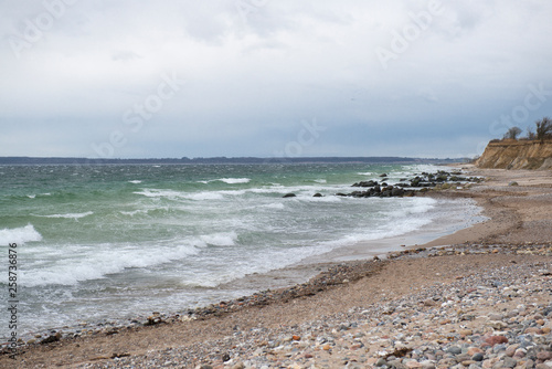 View of the baltic sea and stone beach, stormy sea waves 