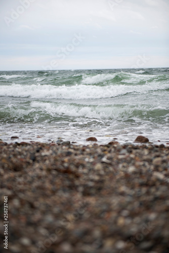 View of the baltic sea and stone beach, stormy sea waves 