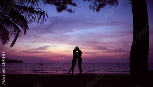Young couple kissing on a romantic, tropical beach