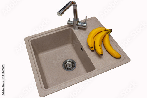 Granite kitchen sink with bananas and stainless two-handle faucet, isolated
