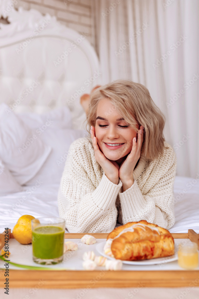 Appealing woman feeling excited before having breakfast in bed Appealing woman feeling excited before having breakfast in bed