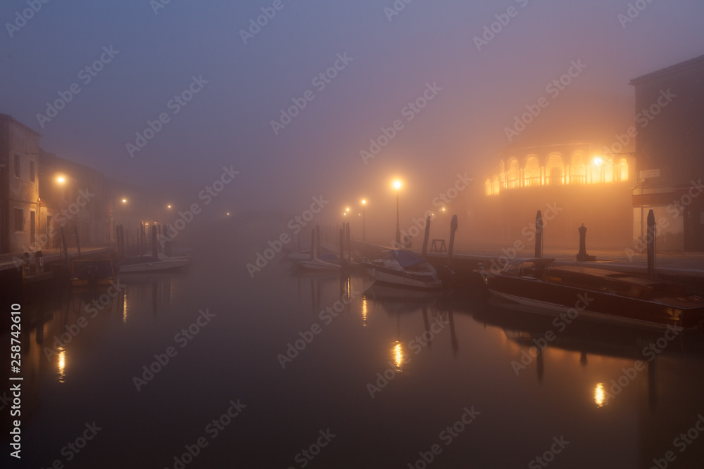 Night view canal on Murano island in the fog