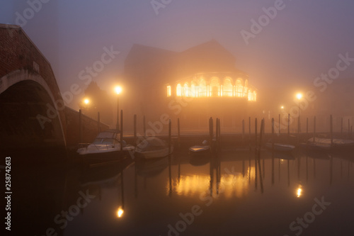 Night view canal on Murano island in the fog