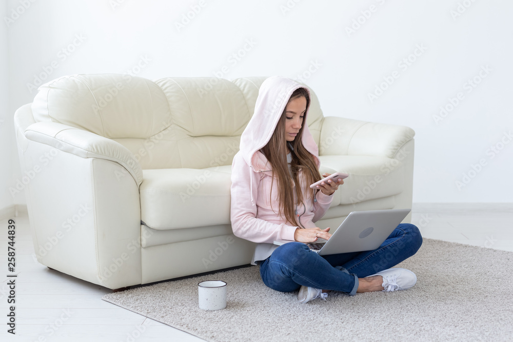 Freelance and people concept - Young woman sitting on floor and working at laptop