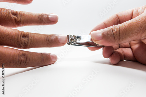 hand manicure with nail clipper on white background