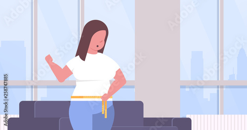 fat obese woman measuring her waistline overweight girl using tape measure weight loss concept modern living room interior flat portrait horizontal