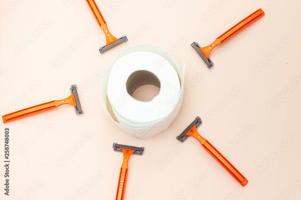 five orange Disposable shaver and toilet paper roll isolated on pink background five orange Disposable shaver and toilet paper roll isolated on pink background