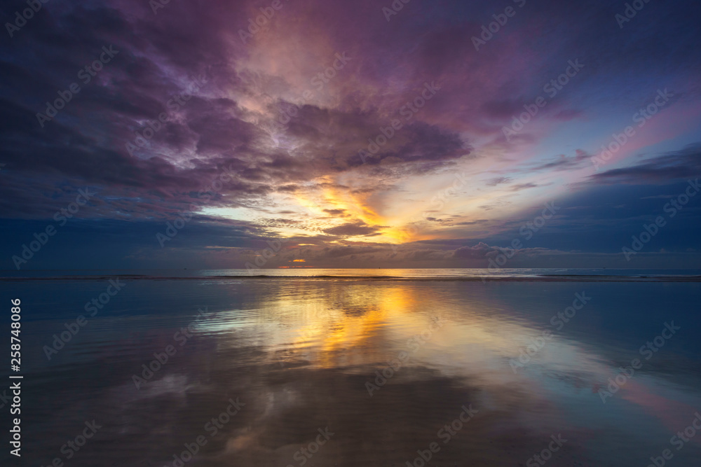 Reflection sunrise at the sea with amazing colorful sky