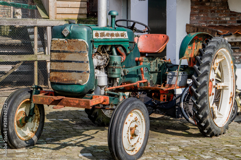 Old American tractor in good condition at farm yard restored looking vintage slightly rusty Old American tractor in good condition at farm yard restored looking vintage slightly rusty