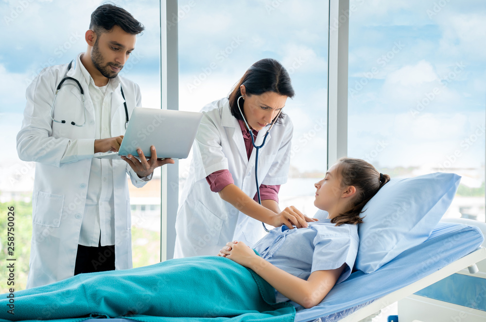 Obraz premium Two doctors are examining the symptoms of female patients. Which uses the laptop to search for patient information In the treatment history in order to properly maintain. Concept Health care