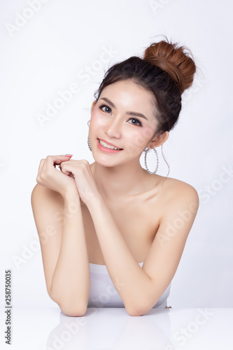 Portrait of attractive asian woman sitting smiling on white background. Healthy skin woman natural makeup beauty face concept. Using as your Product.