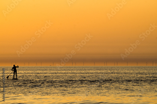 Lonely men silhouette on paddle surfing at sunset on the Zandvoort beach in the Netherlands.jpg