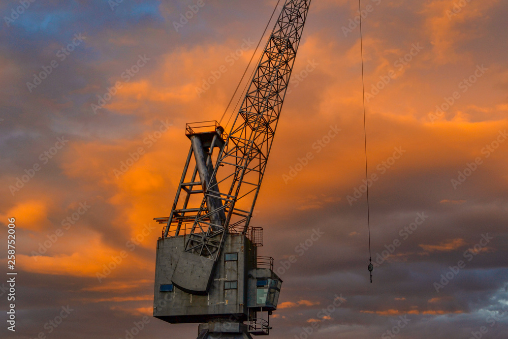 old rusty crane on sunset 