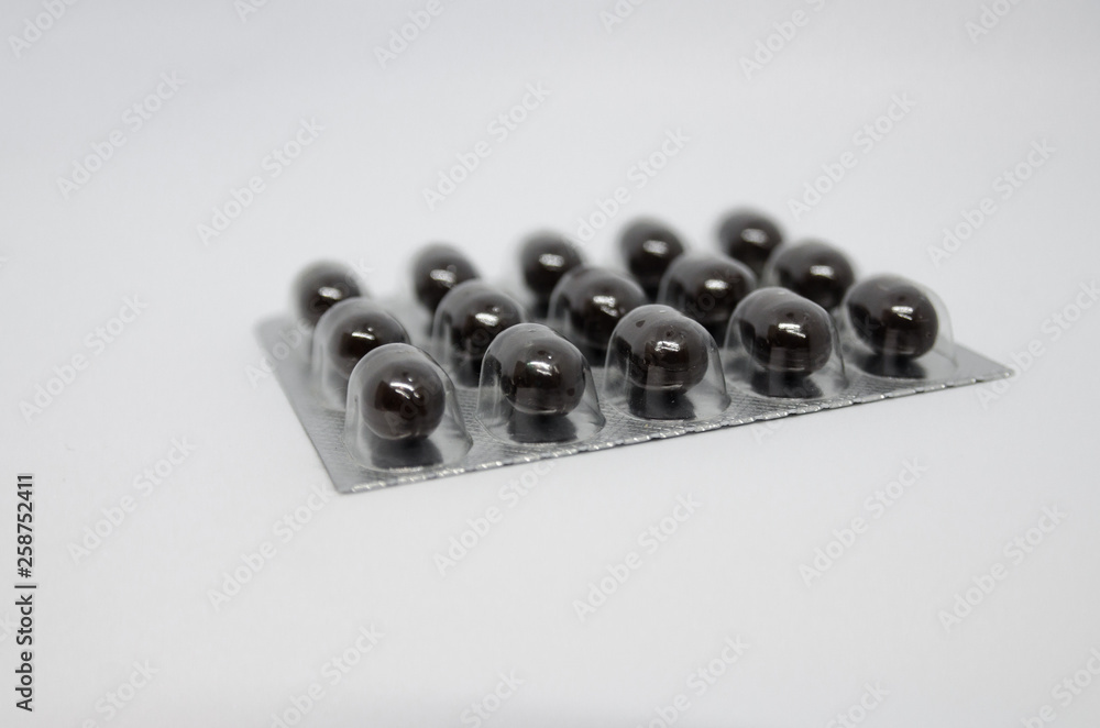 A packing of medical black pills A packing of medical black pills