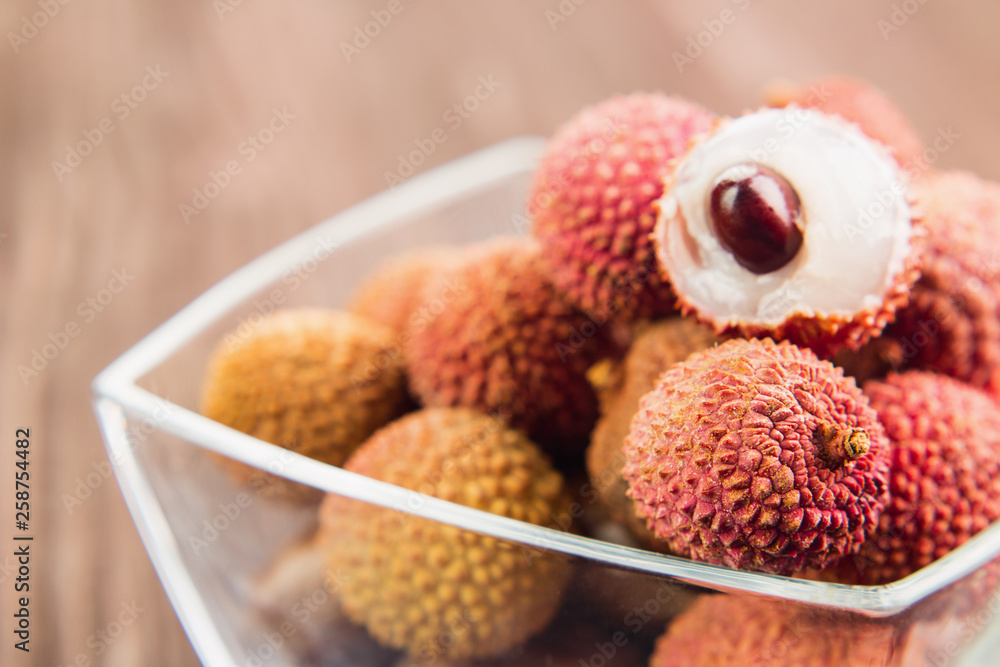 Fresh organic lychee fruit on brown wooden background Fresh organic lychee fruit on brown wooden background