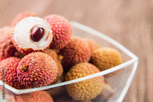 Fresh organic lychee fruit on brown wooden background