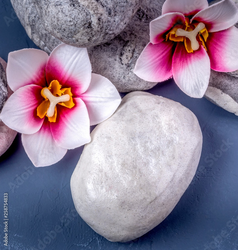 Spa composition with stones, flowers and a burning candle