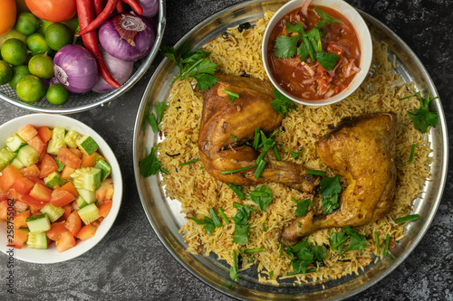 chicken mandy rice set with spicy sauce and salad on dark background
