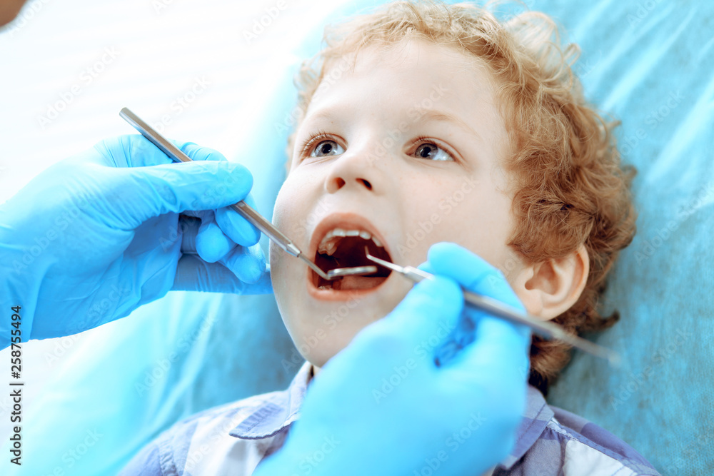Doctor and patient child. Boy having his teeth examined with dentist. Medicine, health care and stomatology concept Doctor and patient child. Boy having his teeth examined with dentist. Medicine, health care and stomatology concept