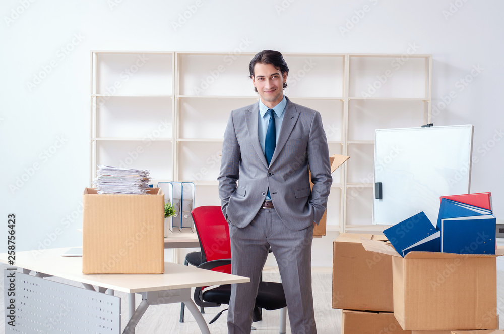 Young man employee with boxes in the office Young man employee with boxes in the office